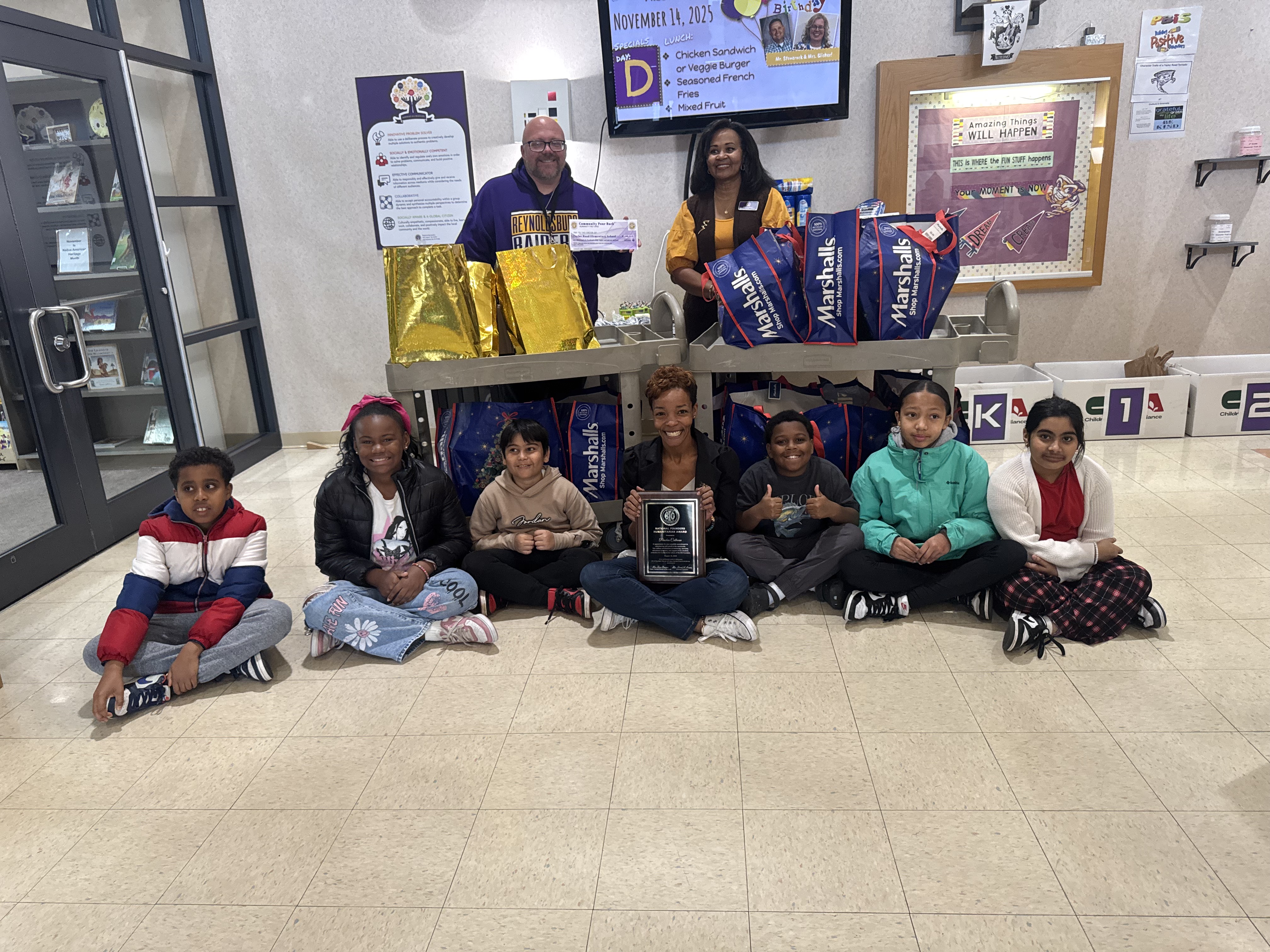 Peaches Calhoun presenting school supplies and a donation check to Taylor Road Elementary staff alongside Principal and former Reynoldsburg School Board President Angela Abrams during the annual HFO Gives Back to Teachers event.